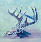 colorful oil painting of a deer skull with a large rack of antlers, leaning on a book - colors are jewel-toned pinks, purples, yellows and blues