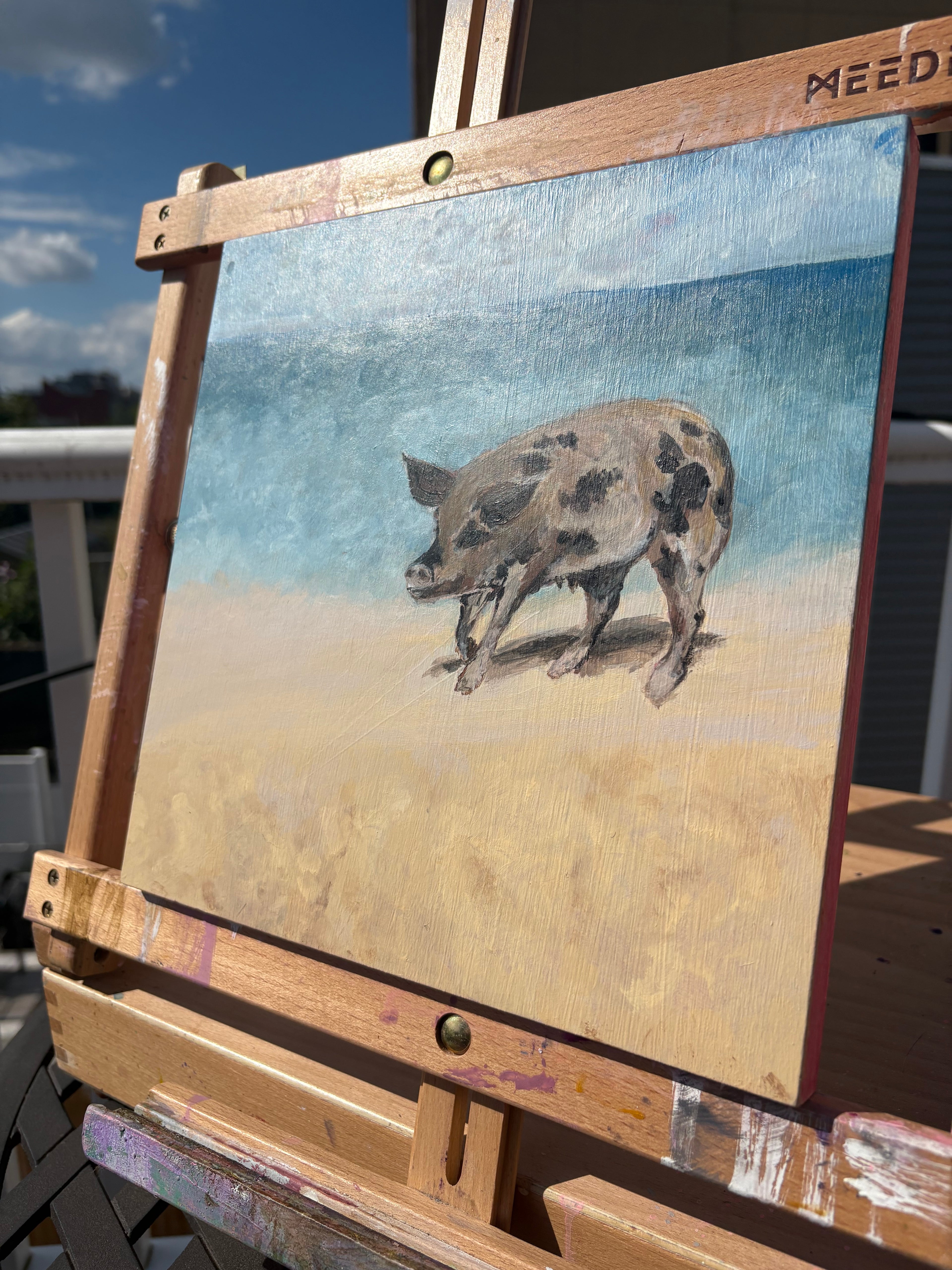 Angled detail image of an oil painting of a big spotted pig on a beach