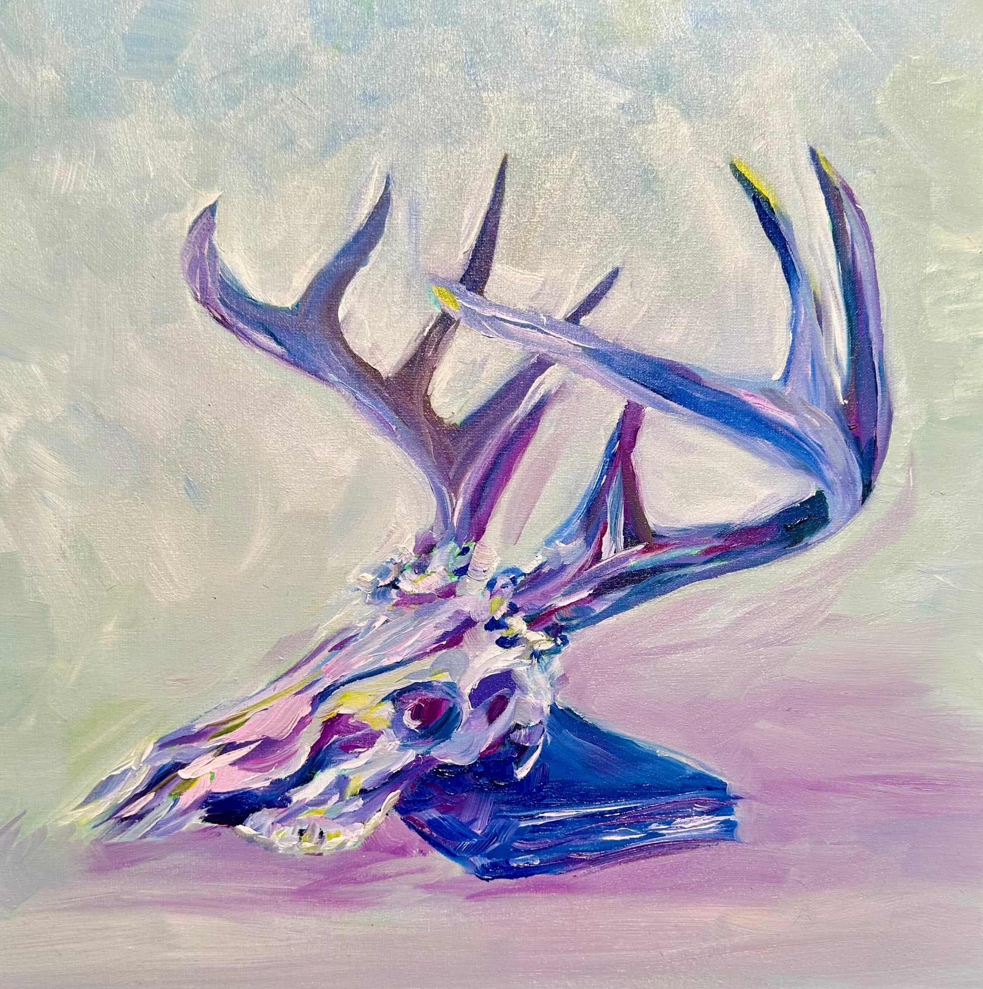 colorful oil painting of a deer skull with a large rack of antlers, leaning on a book - colors are jewel-toned pinks, purples, yellows and blues